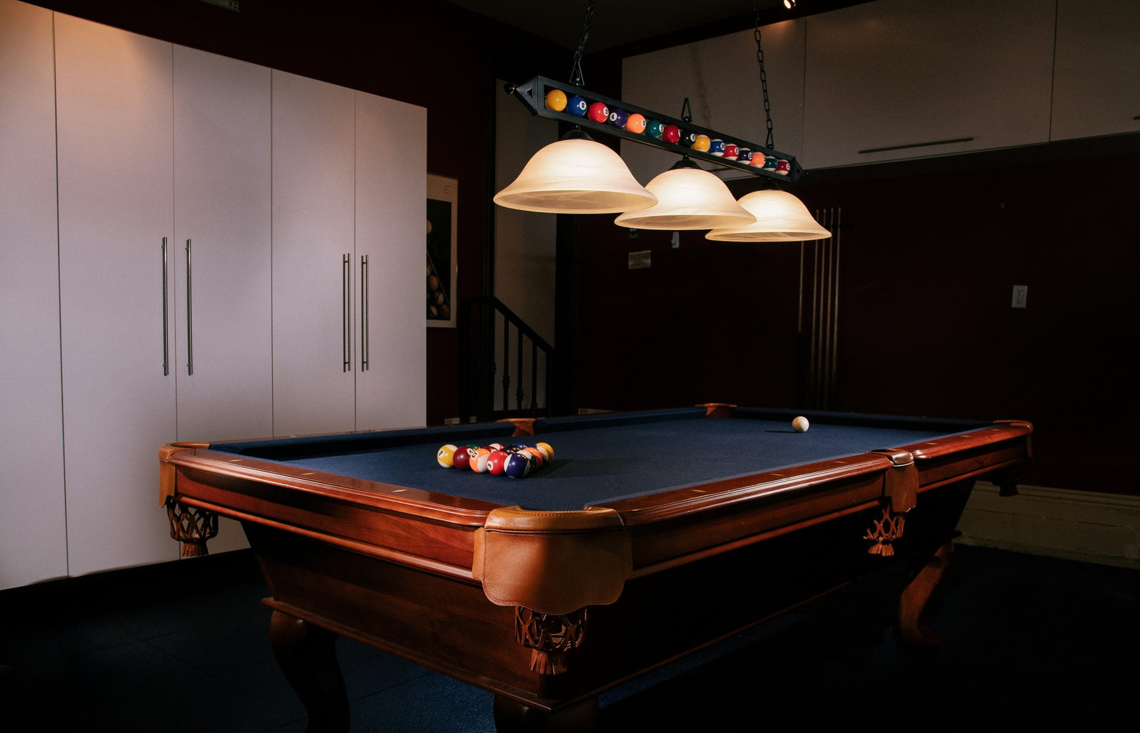 A Wooden Billiard Table in a Dim Lit Game Room