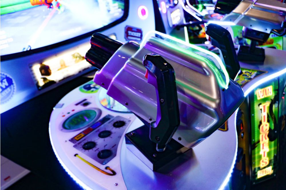 A photo showing two mini guns attached to an arcade machine with glowing features and lightings