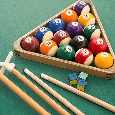 Pool table accessories collection with cues, racks, chalk, and table covers
