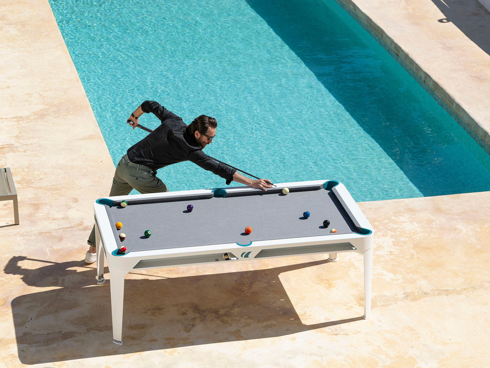 Man playing pool by a pool