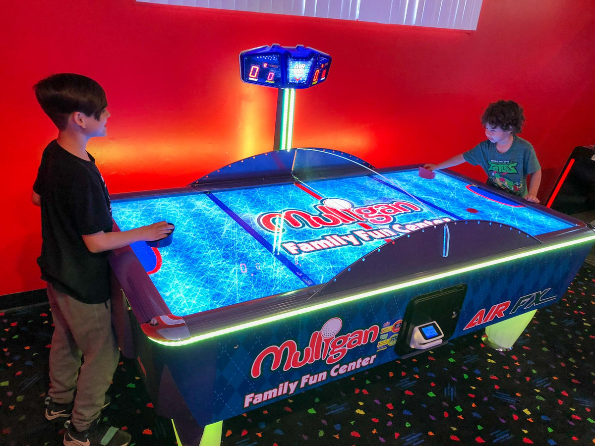 Air FX full-size 8-foot air hockey table with LED-lit playfield and ½-inch thick commercial-grade surface.