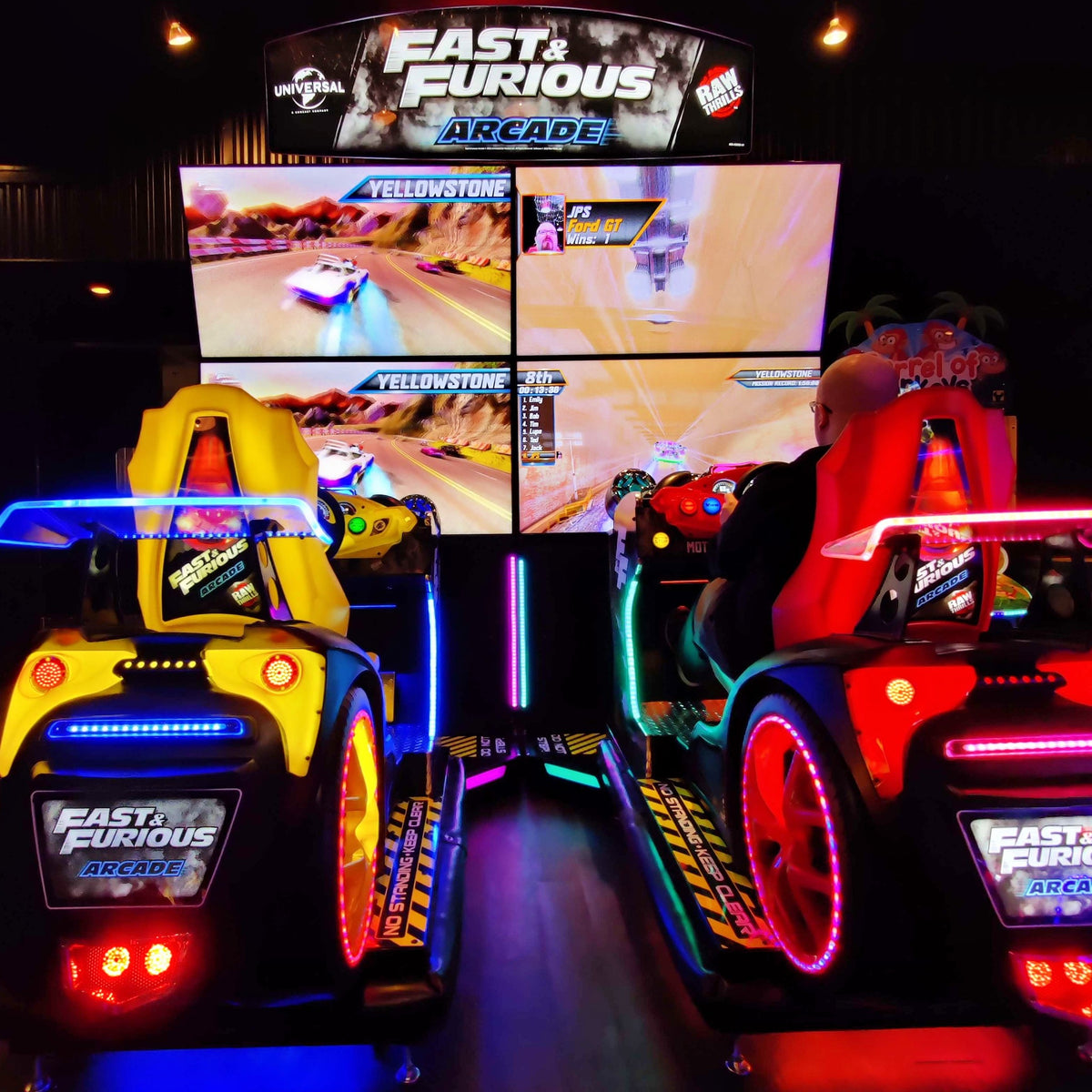 Fast & Furious Thrill-D motion racing arcade machine with dual 65-inch UHD screens, motion simulator, and 1–8 player linked cabinets