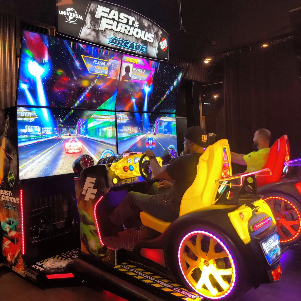 Fast & Furious Thrill-D motion racing arcade machine with dual 65-inch UHD screens, motion simulator, and 1–8 player linked cabinets