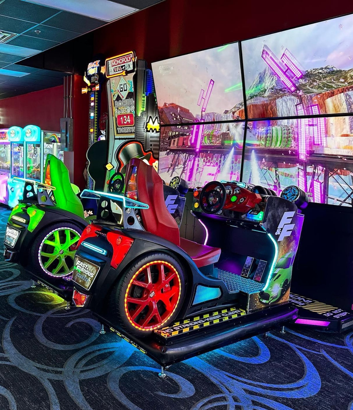 Fast & Furious Thrill-D motion racing arcade machine with dual 65-inch UHD screens, motion simulator, and 1–8 player linked cabinets