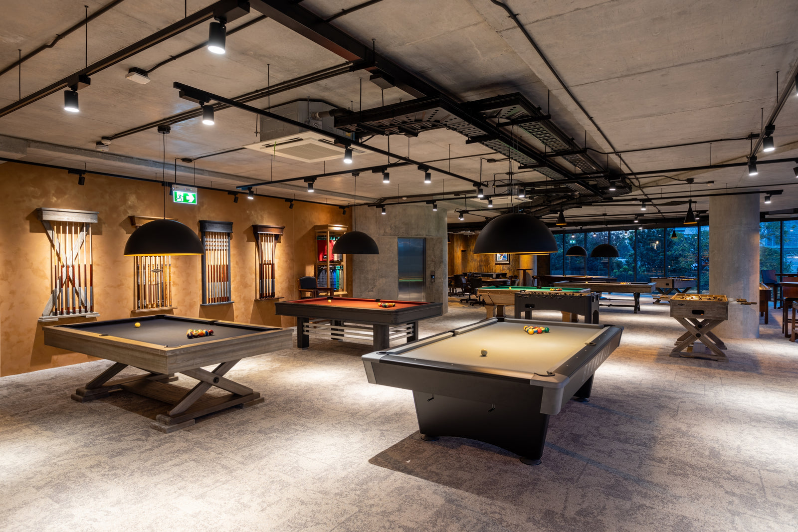 Indoor recreational area with pool tables and a bar.