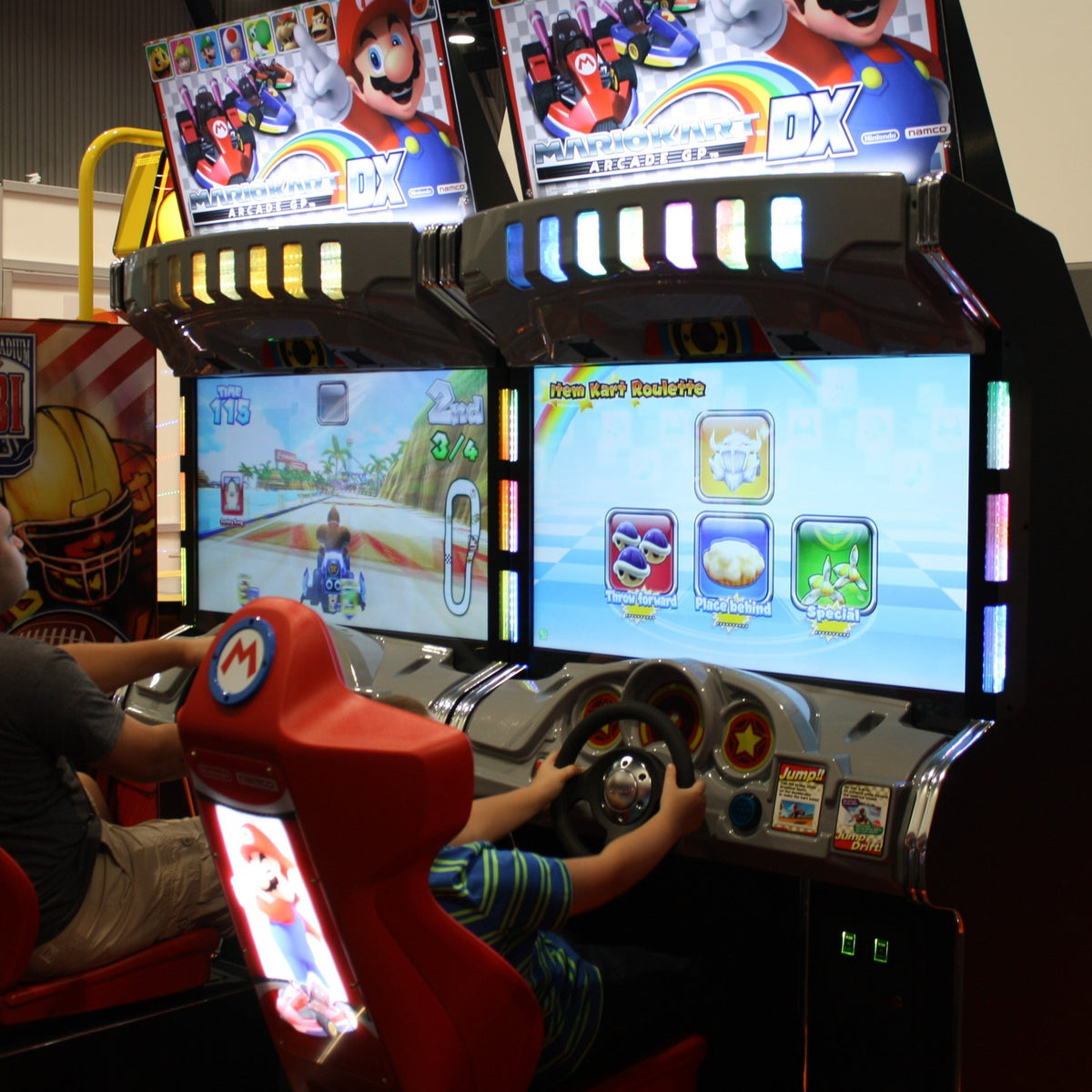 Mario Kart GP DX arcade driving game with 42-inch HD monitor, linkable 4-player racing, and rainbow LED cabinet.