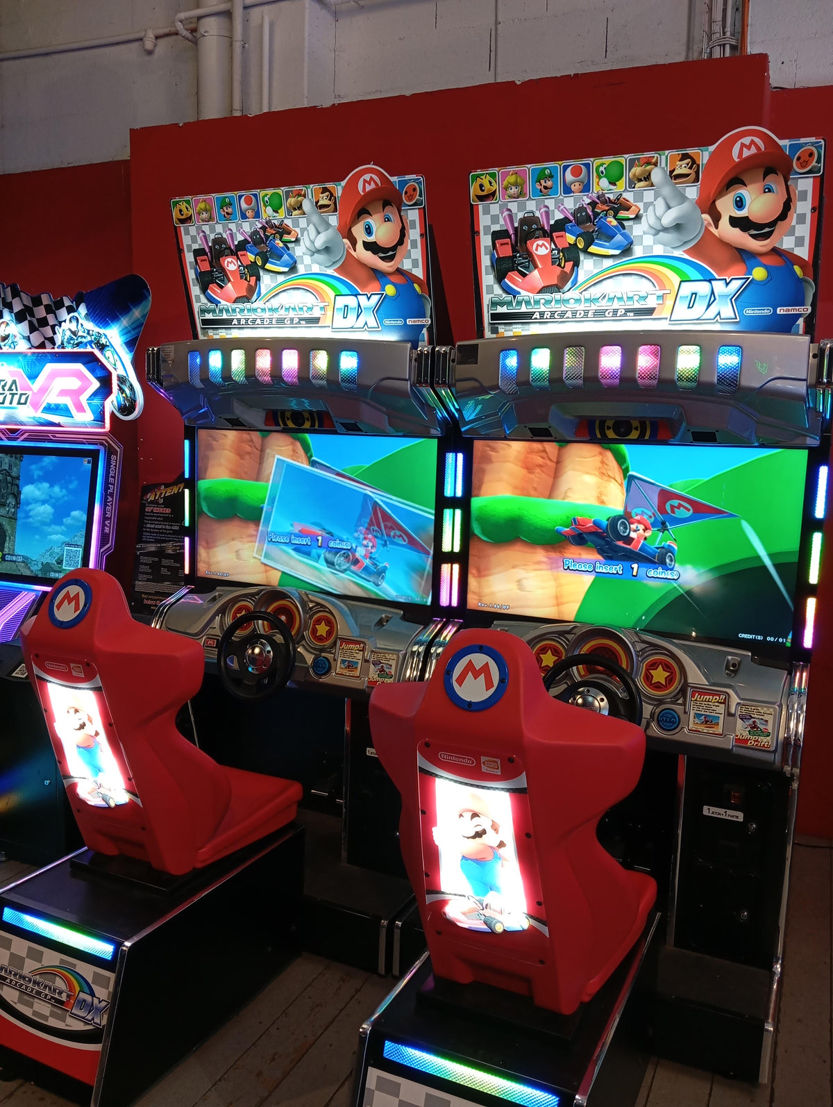 Mario Kart GP DX arcade driving game with 42-inch HD monitor, linkable 4-player racing, and rainbow LED cabinet.