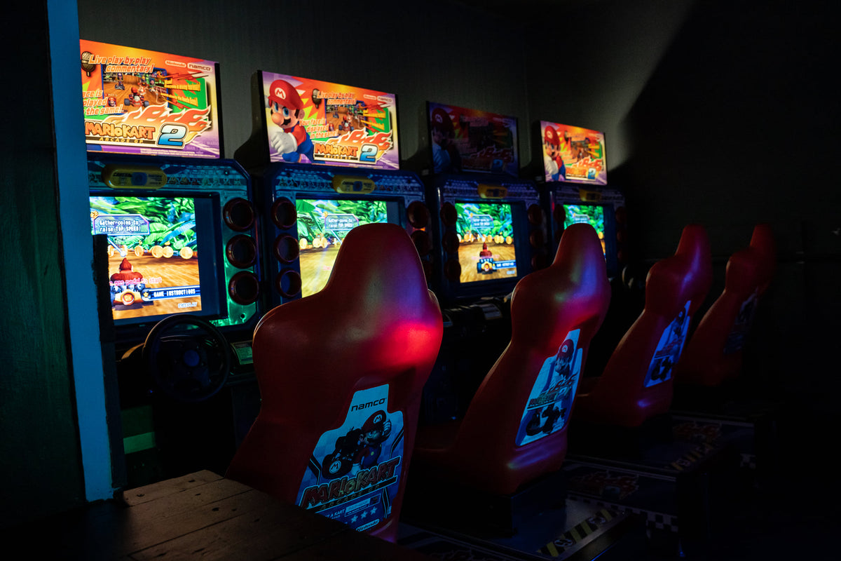 Mario Kart GP DX arcade driving game with 42-inch HD monitor, linkable 4-player racing, and rainbow LED cabinet.