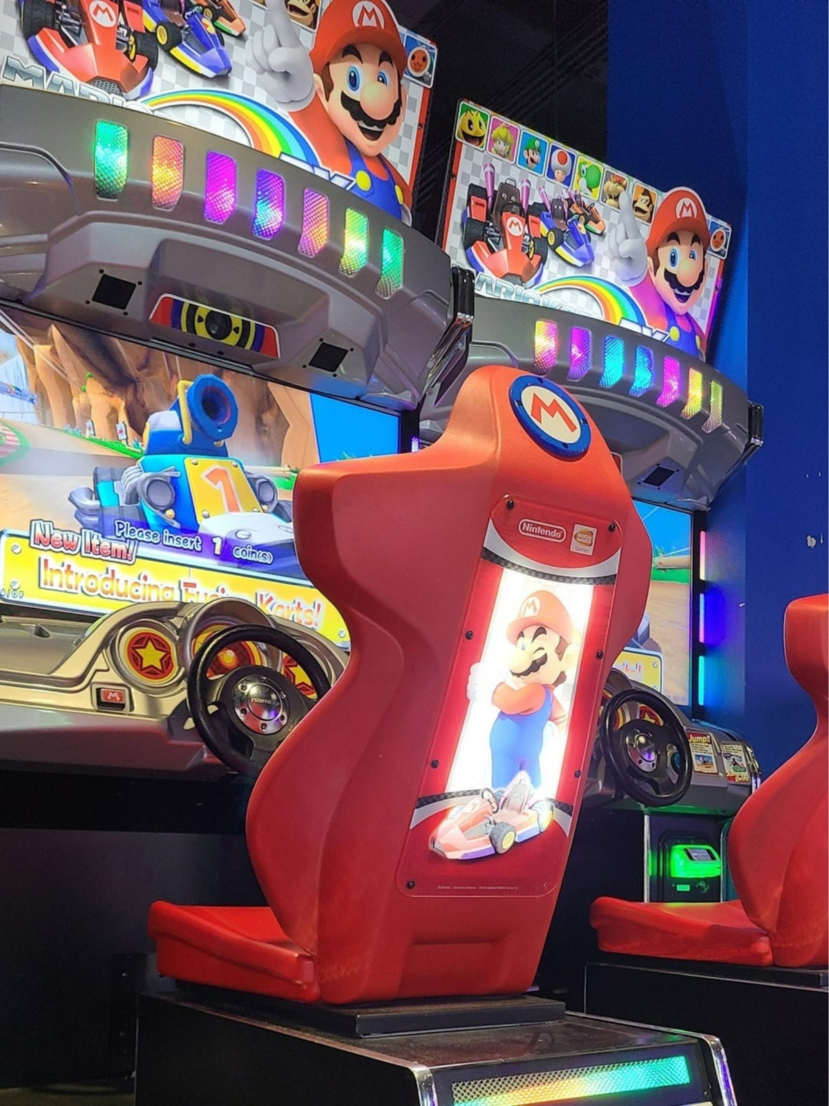 Mario Kart GP DX arcade driving game with 42-inch HD monitor, linkable 4-player racing, and rainbow LED cabinet.