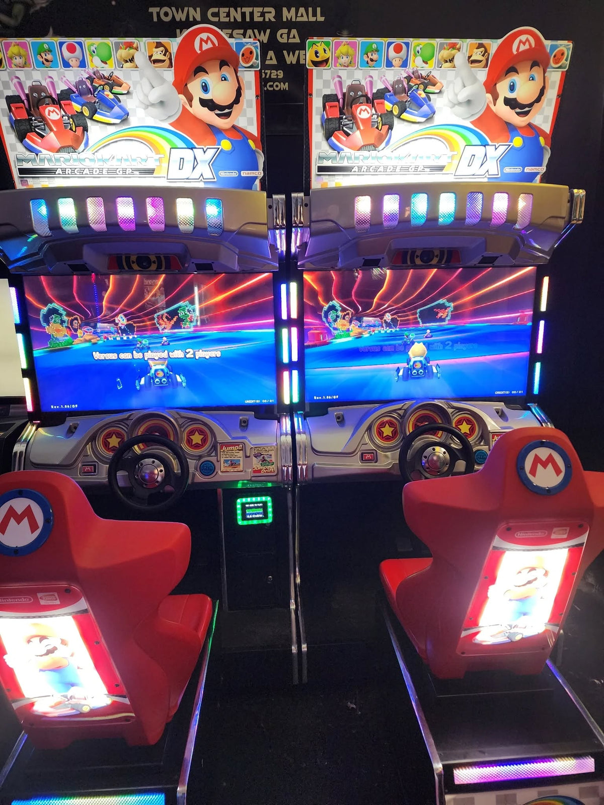 Mario Kart GP DX arcade driving game with 42-inch HD monitor, linkable 4-player racing, and rainbow LED cabinet.