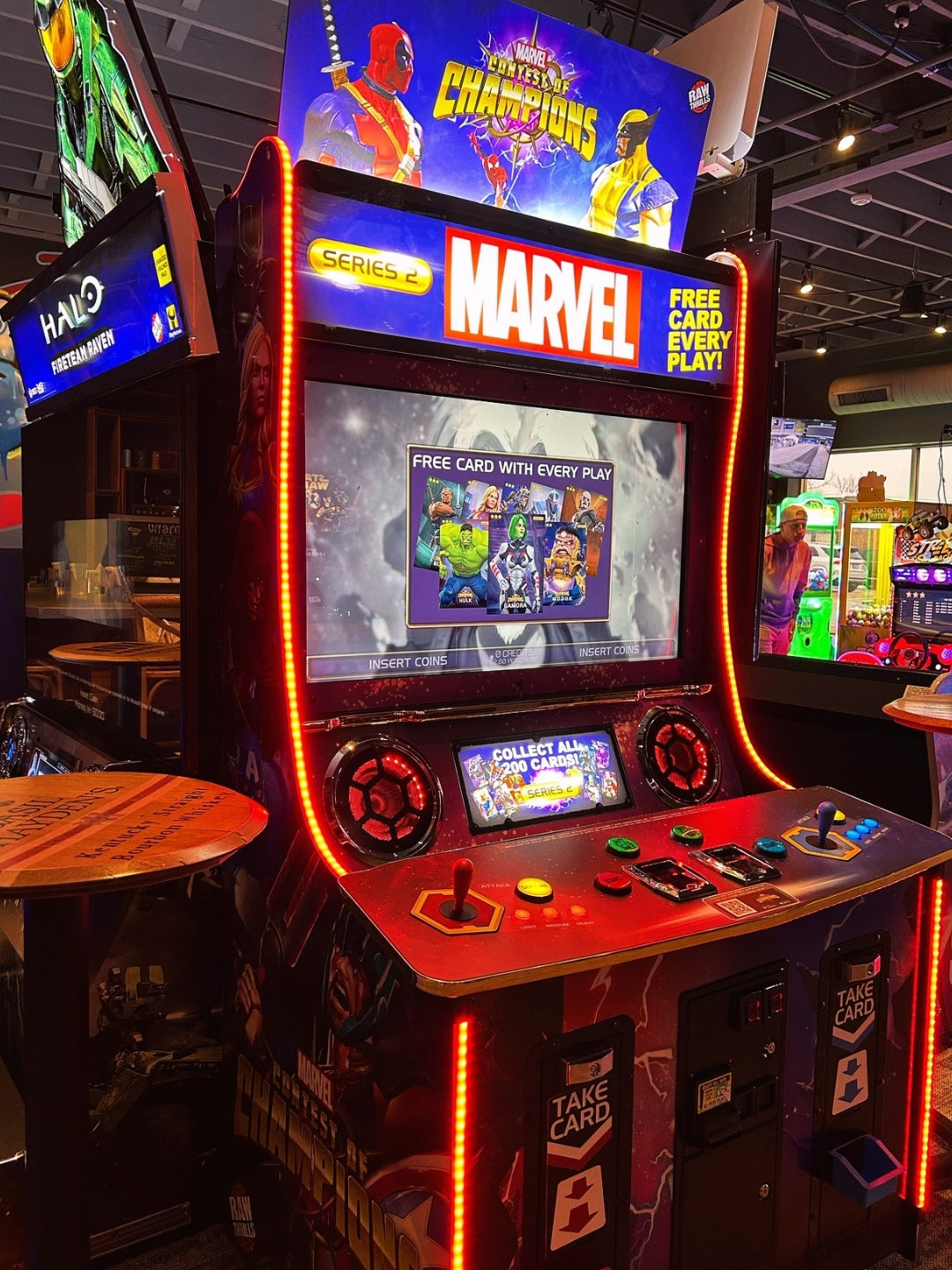 Marvel Contest of Champions arcade machine with 43-inch HD display, 2-player 3v3 fighting gameplay, and collectible champion cards.
