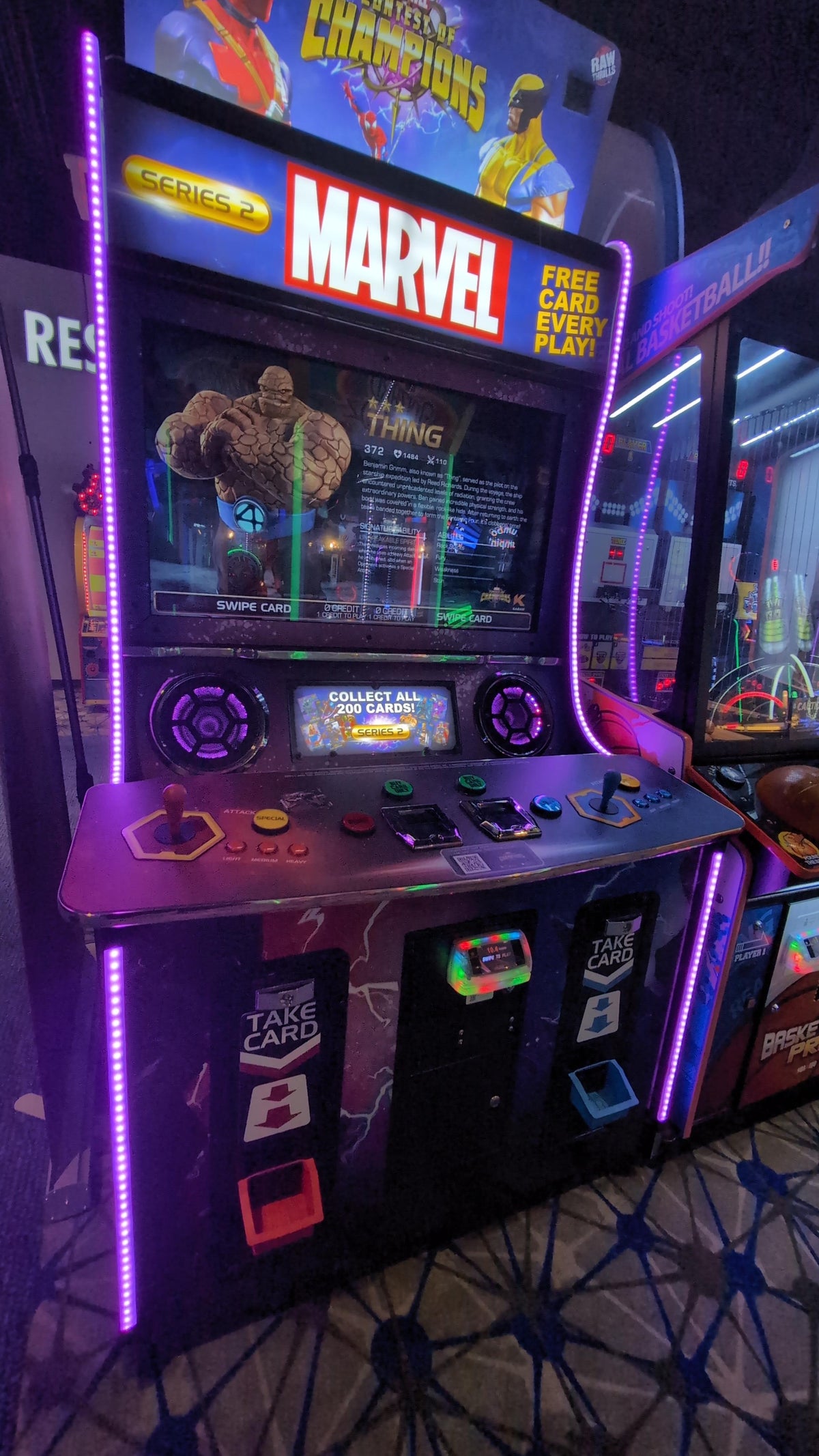 Marvel Contest of Champions arcade machine with 43-inch HD display, 2-player 3v3 fighting gameplay, and collectible champion cards.