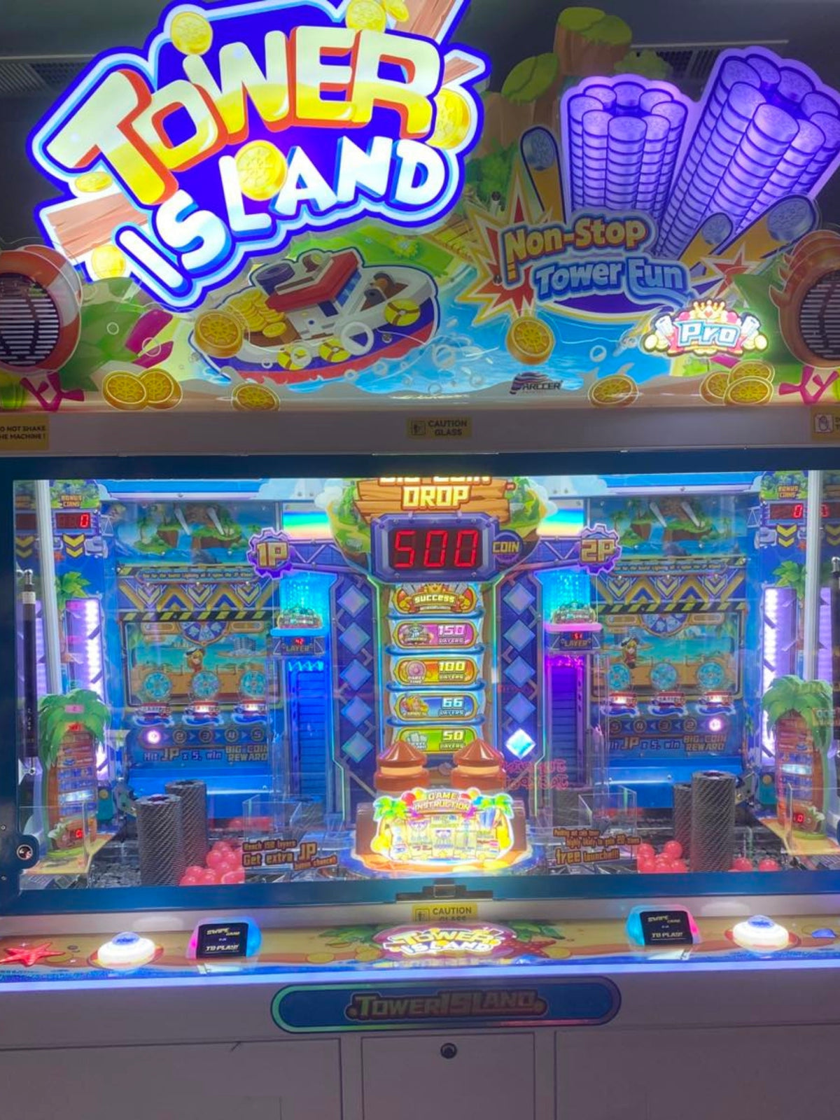 Namco Tower Island 2-player pusher arcade game with multi-level coin pusher action and LED-lit tropical cabinet.