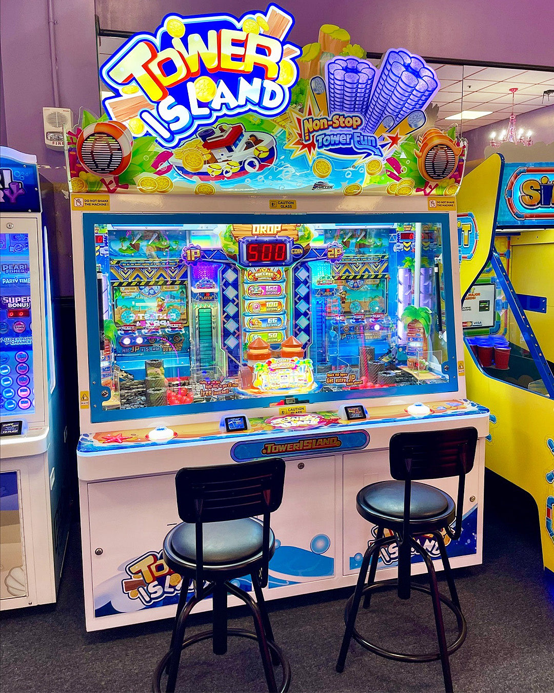 Namco Tower Island 2-player pusher arcade game with multi-level coin pusher action and LED-lit tropical cabinet.