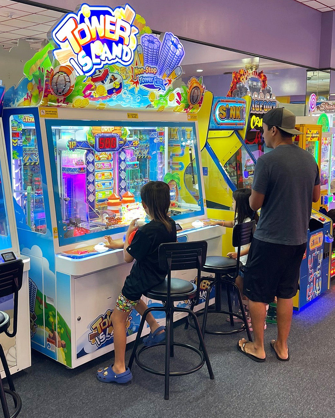 Namco Tower Island 2-player pusher arcade game with multi-level coin pusher action and LED-lit tropical cabinet.