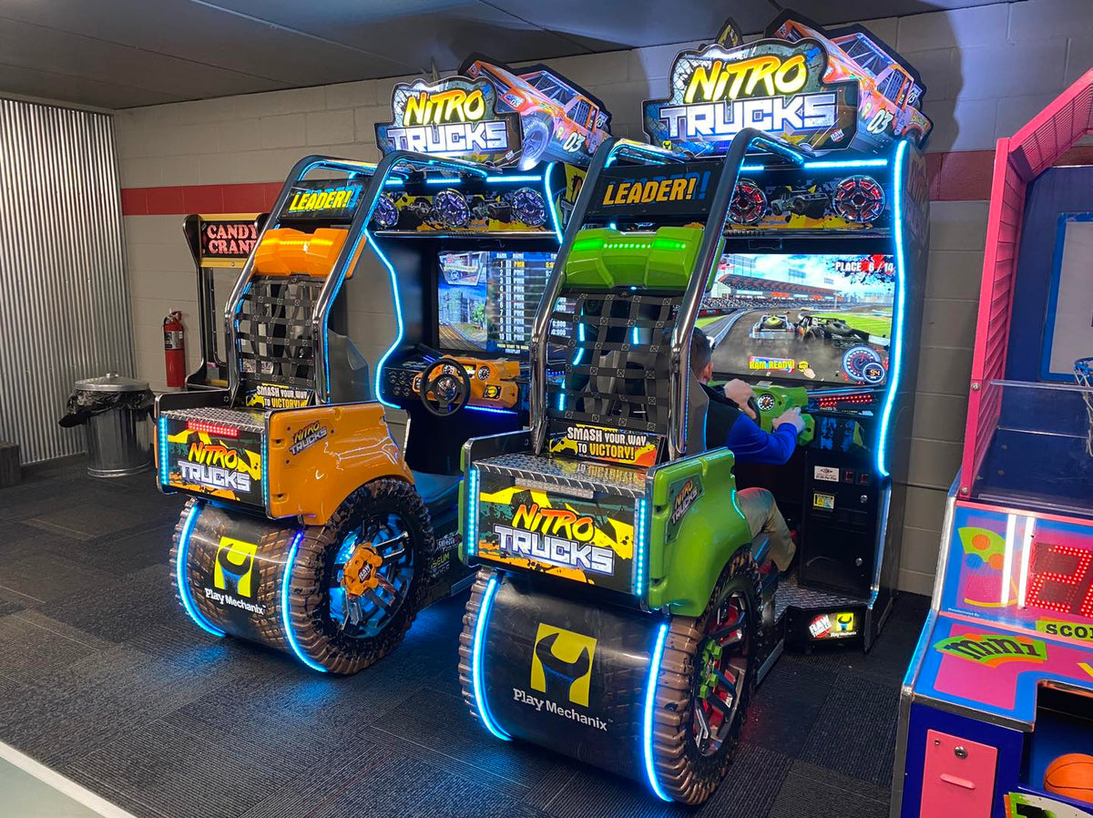 Nitro Trucks arcade machine with 43-inch HD display and force feedback steering for immersive monster truck racing.