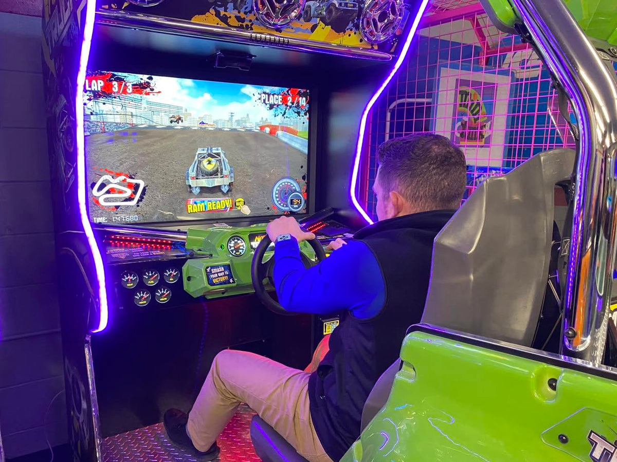 Nitro Trucks arcade machine with 43-inch HD display and force feedback steering for immersive monster truck racing.