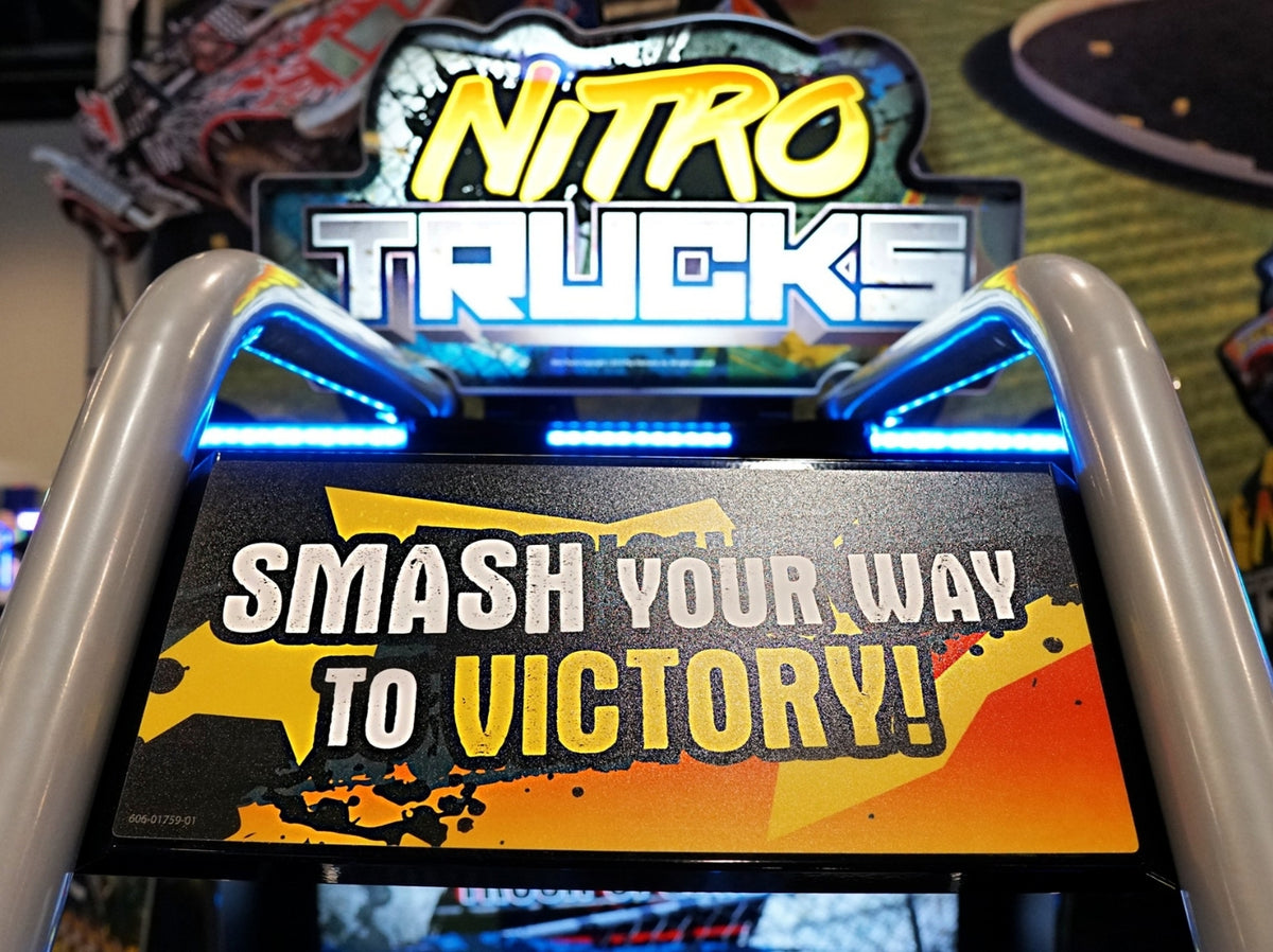 Nitro Trucks arcade machine with 43-inch HD display and force feedback steering for immersive monster truck racing.