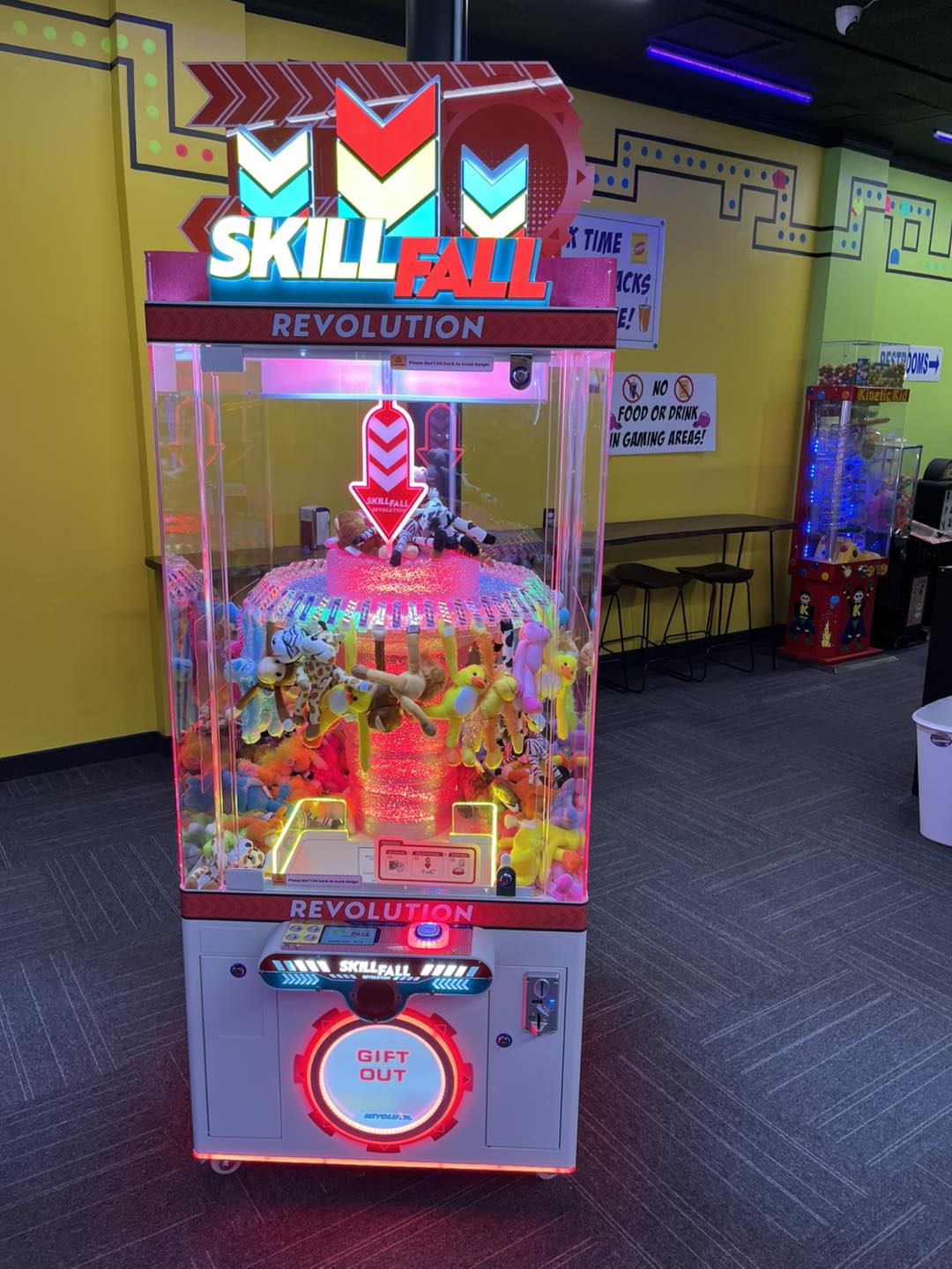 Skill Fall Revolution red cabinet prize redemption arcade machine with vertical drop gameplay and bright LED prize compartments