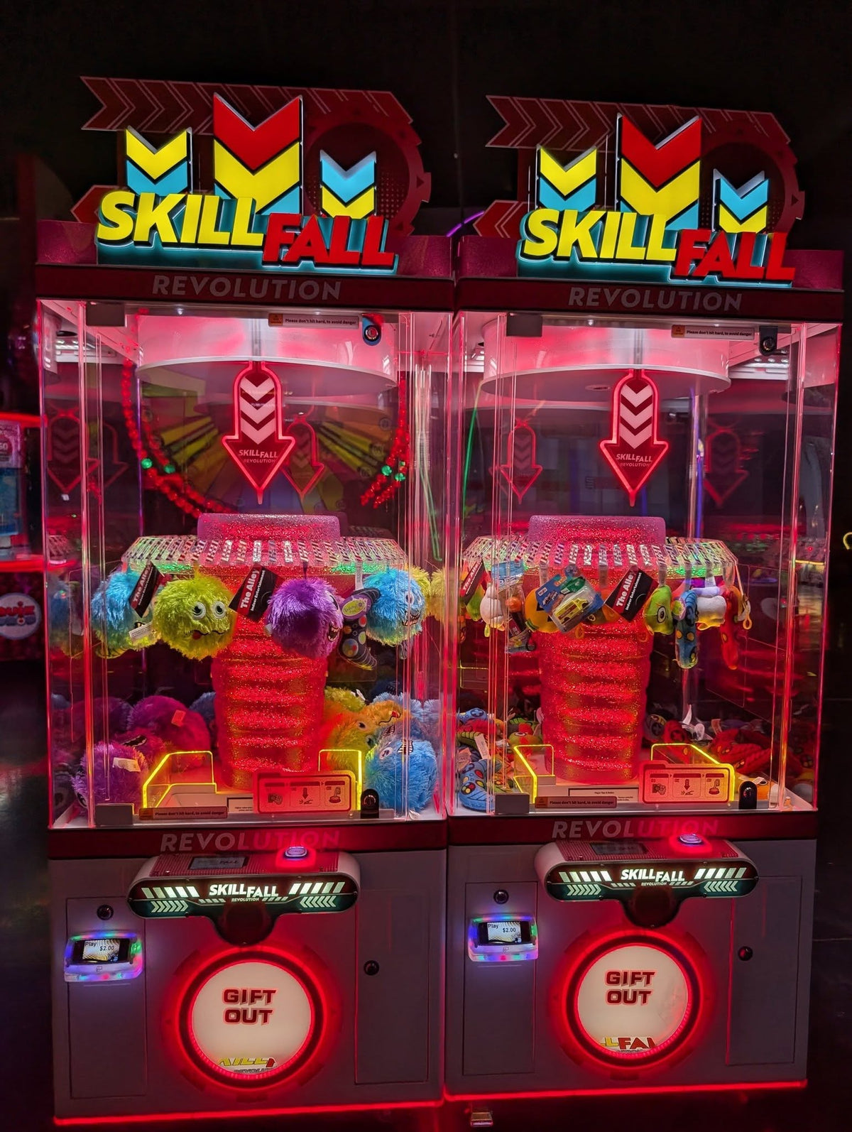 Skill Fall Revolution red cabinet prize redemption arcade machine with vertical drop gameplay and bright LED prize compartments