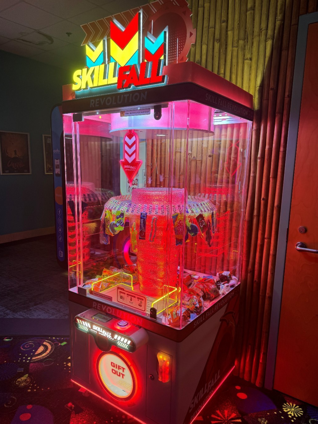Skill Fall Revolution red cabinet prize redemption arcade machine with vertical drop gameplay and bright LED prize compartments