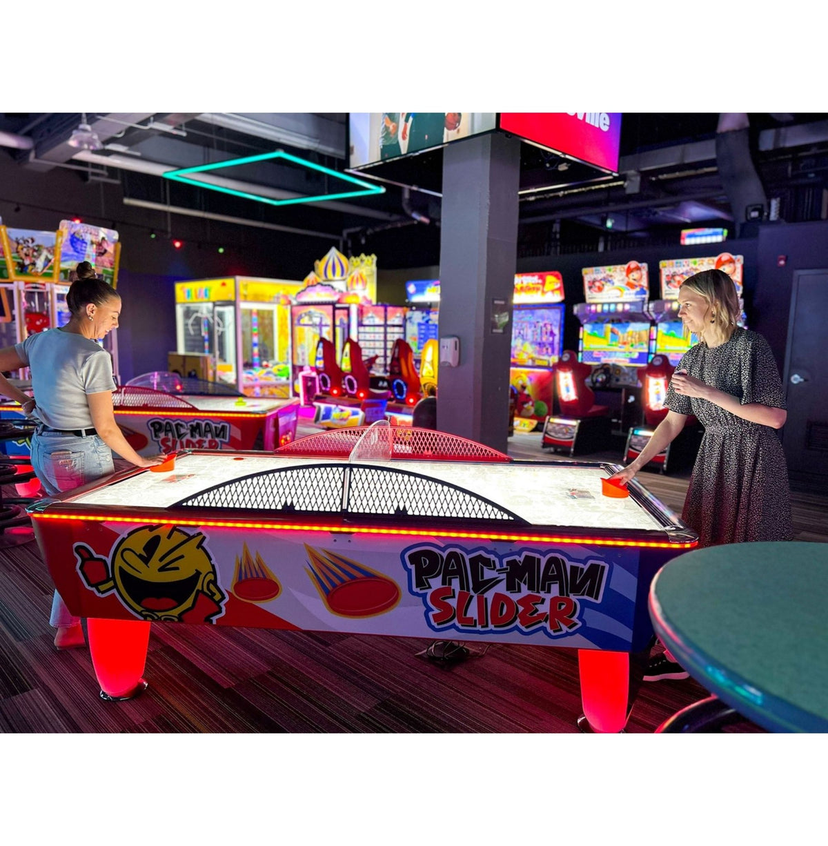 Pac-Man Slider air hockey table with LED color-changing playfield, classic Pac-Man sounds, and durable coin-operated design.