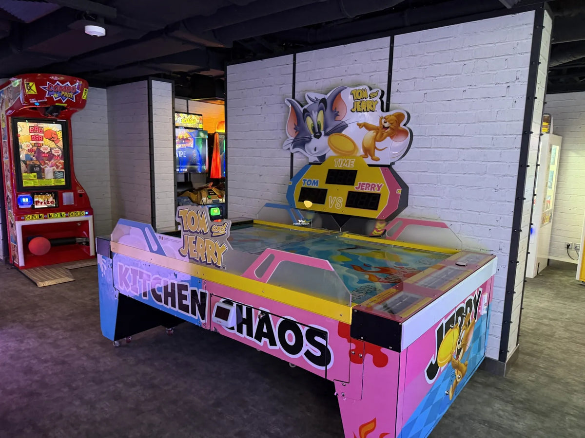 Tom & Jerry Kitchen Chaos air hockey table with multi-puck arcade action and cartoon-themed LED cabinet.