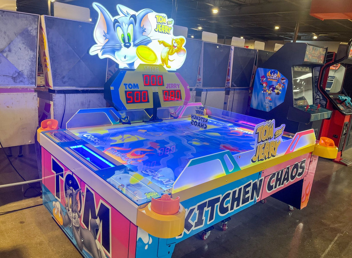 Tom & Jerry Kitchen Chaos air hockey table with multi-puck arcade action and cartoon-themed LED cabinet.